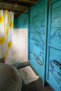 een badkamer met een wastafel en een blauwe muur bij El Vijo Surf in Nuquí