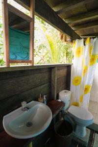 un baño con lavabo e inodoro en El Vijo Surf, en Nuquí