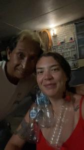 kobieta stojąca obok mężczyzny trzymającego butelkę wody w obiekcie Apollo Hostel w mieście Lovina