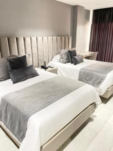 um quarto com 2 camas e uma grande cabeceira em Hotel Plaza Doce em Pereira