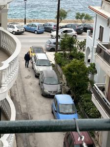 un hombre caminando por una calle con coches aparcados en Scarlett City Apartment, en Zakynthos