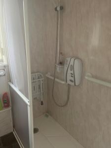a bathroom with a shower with a hair dryer on the wall at Princess Gardens Liverpool Accessible - Infinity in Liverpool