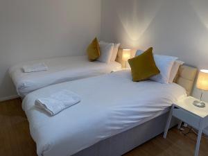 two twin beds in a room with two lamps at Princess Gardens Liverpool Accessible - Infinity in Liverpool