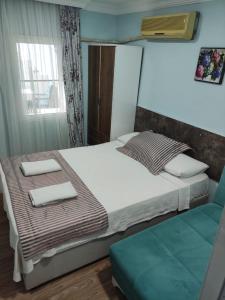 een slaapkamer met een bed met twee handdoeken erop bij LAVİNYA PENSİON in Kuşadası