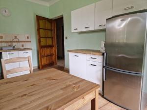 a kitchen with a stainless steel refrigerator and a wooden table at Cichy Zakątek Kłodzko in Kłodzko