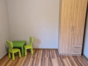 a room with a green table and two chairs at Cichy Zakątek Kłodzko in Kłodzko