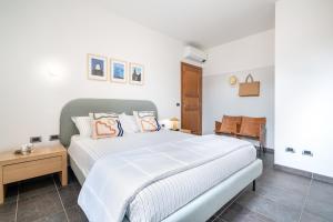 a white bedroom with a bed and a table at The Park View Place in Olbia