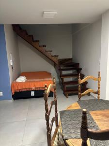 a room with a bed and a staircase with a table at Casa Ouro no centro de Diamantina in Diamantina