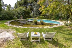 una mesa y sillas en un patio con piscina en Catalunya Casas Rural charm on an olive farm in Costa Dorada!, en Vespellà