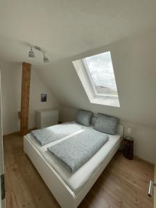um quarto com uma cama com duas almofadas e uma janela em Ferienwohnung Hajü em Herrischried