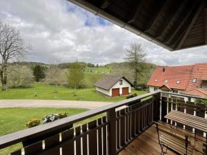 uma varanda com vista para um campo e uma casa em Ferienwohnung Hajü em Herrischried
