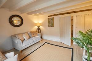 a living room with a couch and a mirror at Host & Stay - Acorn Cottage in Guisborough