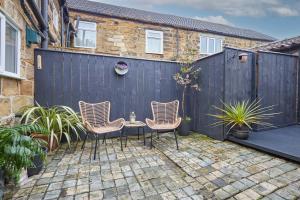 un patio con 3 sillas y una valla en Host & Stay - Acorn Cottage, en Guisborough
