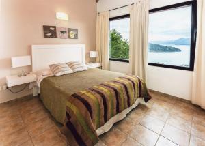 a bedroom with a bed and a large window at Catalonia Sur Aparts in San Carlos de Bariloche +96 photos
