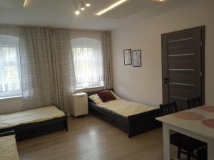 sypialnia z 2 łóżkami, stołem i oknem w obiekcie WOLSKA APARTMENT 80m2 - 7 people, 3 rooms we Wrocławiu