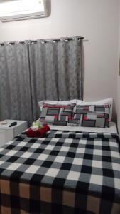 uma cama com um cobertor xadrez preto e branco em Império Locações para Temporada em Olímpia
