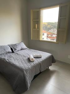 迪亞曼蒂納的住宿－Casa Ouro no centro de Diamantina，一间卧室配有一张床,上面有两条毛巾