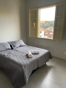 a bedroom with a bed with two towels on it at Casa Ouro no centro de Diamantina in Diamantina