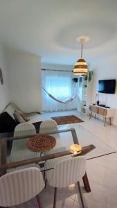 uma sala de estar com uma mesa de vidro e cadeiras em Ria Mar Fuzeta Apartments na Fuzeta