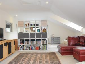 a living room with a couch and a book shelf at Sherwell Farm Annexe in Callington