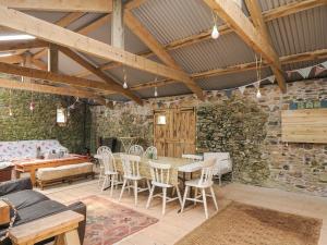 a room with a table and chairs and a stone wall at Sherwell Farm Annexe in Callington