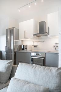 a kitchen with stainless steel appliances and white cabinets at The Park View Place in Olbia