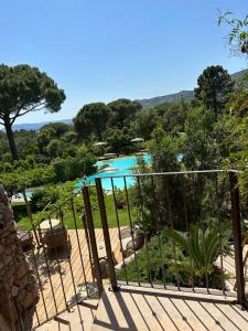 a view of a pool from the balcony of a resort at Hôtel Ambassador Palombaggia in Porto-Vecchio