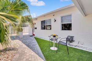 a patio with a table and chairs in front of a house at Soleil @ Casa Del Sol in Fort Lauderdale