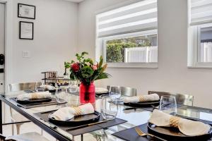 Un comedor con una mesa larga con un jarrón de flores. en Soleil @ Casa Del Sol, en Fort Lauderdale 37 fotos más