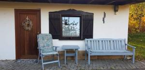 due sedie e un tavolo di fronte a una casa di Haus Andrea a Lichtenberg
