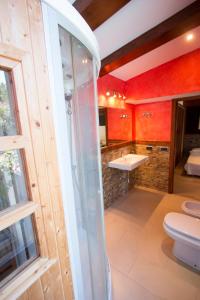 La salle de bains est pourvue d'une douche en verre et de toilettes. dans l'établissement Catalunya Casas An oasis for up to 26 nature loving guests!, à Sils