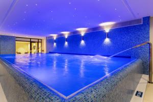 een zwembad in een hotel met een blauw plafond bij Maritim Hotel Ingolstadt in Ingolstadt