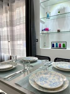 einen Tisch mit Tellern und Gläsern darüber in der Unterkunft L'atelier - Locazione turistica in Scilla