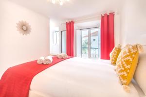 リスボンにあるAlfama Lovely Duplexのベッドルーム1室(赤いカーテン付きの大型ベッド1台付)