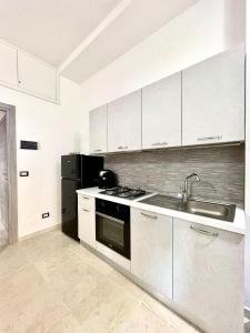 a kitchen with a sink and a stove and a refrigerator at L'atelier - Locazione turistica in Scilla +8 photos