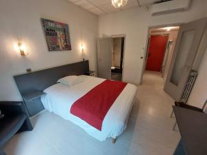 una camera con un letto con una coperta rossa e bianca di Logis Hotels - Hôtel Le Relais des Garrigues a Grisolles