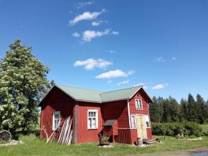 a red barn sitting on top of a field at ReindeerNook in Kuusamo