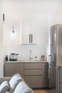 a kitchen with white cabinets and a stainless steel refrigerator at The Park View Place in Olbia