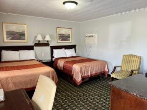 a hotel room with two beds and a table and chairs at Chief Motel in Keokuk