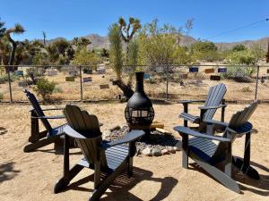 a group of chairs sitting next to a fire pit at Float Pool, Hot Tub, Sauna, Firepit, BBQ, Telescope, Views, EV Chg, in Joshua Tree