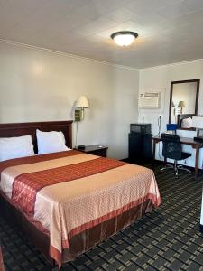 a hotel room with a bed and a desk at Chief Motel in Keokuk