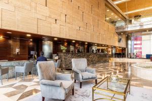 Hotel de Convenções de Talatona, HCTA في لواندا: لوبي فندق فيه كراسي وبار