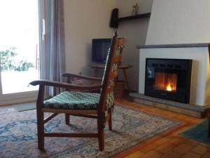 sala de estar con silla y chimenea en Eco-Casa Paradiso G, Schwimmbad, Garten und wunderschöne Seesicht, ruhig und sonnig Gelegen, en Minusio