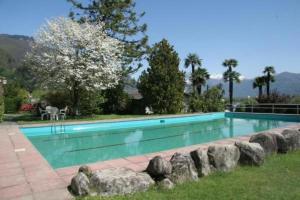 una piscina en un patio con rocas alrededor en Eco-Casa Paradiso G, Schwimmbad, Garten und wunderschöne Seesicht, ruhig und sonnig Gelegen, en Minusio