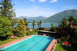 una piscina con vistas al lago y a las montañas en Eco-Casa Paradiso G, Schwimmbad, Garten und wunderschöne Seesicht, ruhig und sonnig Gelegen, en Minusio