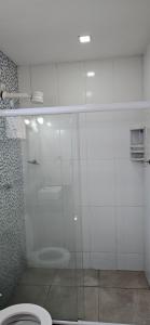 a bathroom with a glass shower with a toilet at Pousada Viva Mar in Saquarema