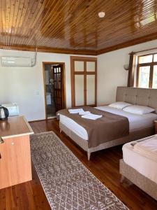 two beds in a room with wooden ceilings and wooden floors at Kekova Pansiyon in Demre