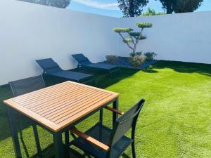 a wooden table and chairs in a yard with grass at Magnifique loveroom in Marseille