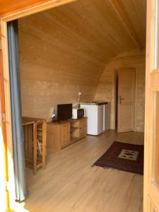 an empty room with a kitchen and a refrigerator at Bungalow 3 personas - Camping Playa de Tapia in Tapia de Casariego