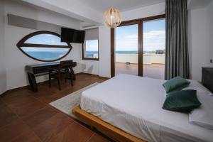 a bedroom with a bed and a desk with a mirror at Mare Apartment Costal Gem in Gázion